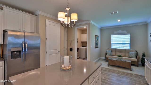 4119 Clifden Dr, Ormond Beach, FL 32174 - kitchen with stainless steel fridge with ice dispenser, white cabinets, wood tiled floors, a chandelier, and crown molding