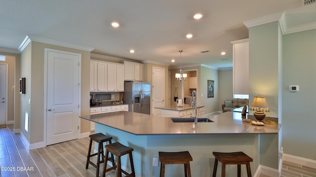 4119 Clifden Dr, Ormond Beach, FL 32174 - kitchen featuring stainless steel fridge, a sink, a kitchen breakfast bar, white cabinetry, and recessed lighting