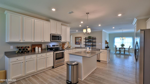 4119 Clifden Dr, Ormond Beach, FL 32174 - kitchen with appliances with stainless steel finishes, a peninsula, a chandelier, ornamental molding, and white cabinetry