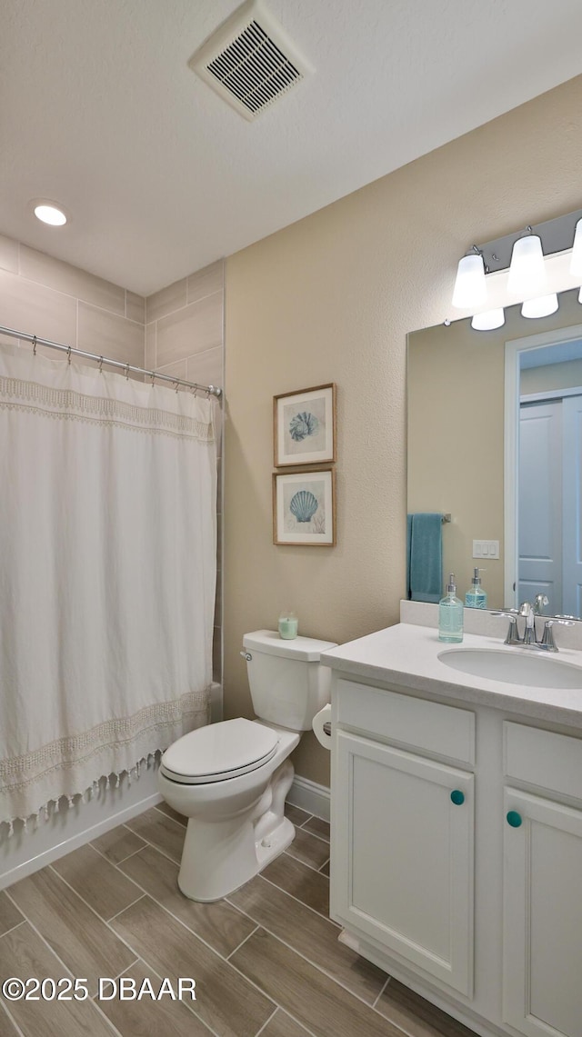 4119 Clifden Dr, Ormond Beach, FL 32174 - bathroom with toilet, vanity, wood finish floors, and shower / tub combo
