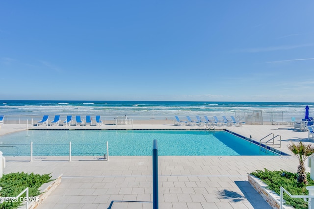 view of swimming pool featuring a patio and a water view