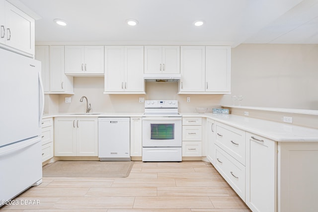 kitchen with white cabinets, kitchen peninsula, white appliances, and sink