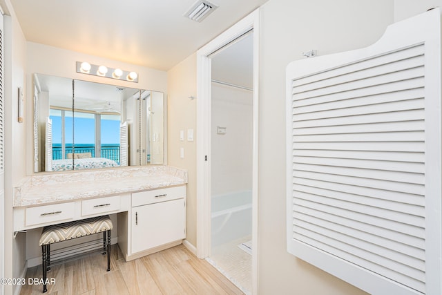 bathroom with wood-type flooring, vanity, and a water view