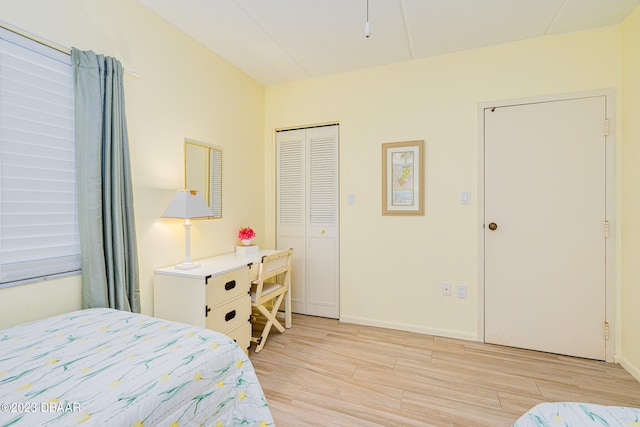 bedroom with light hardwood / wood-style floors and a closet