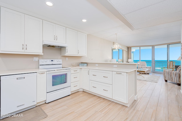 kitchen featuring white appliances, a water view, kitchen peninsula, decorative light fixtures, and white cabinetry