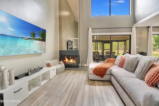 living room with light wood-type flooring and a high ceiling