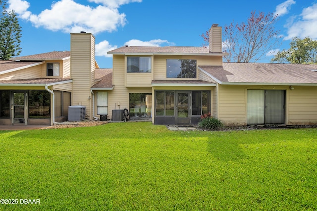 back of property featuring central air condition unit, a yard, and a sunroom