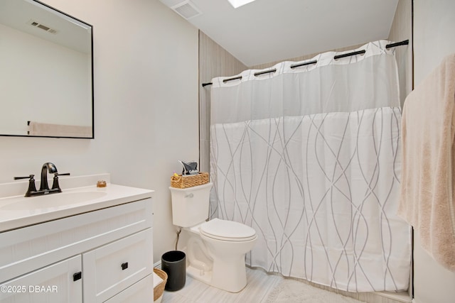 bathroom with toilet, vanity, and a shower with shower curtain