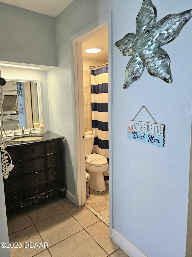 3501 S Atlantic Ave Unit 622, Daytona Beach, FL 32118 - bathroom with tile patterned flooring, toilet, vanity, baseboards, and a shower with shower curtain