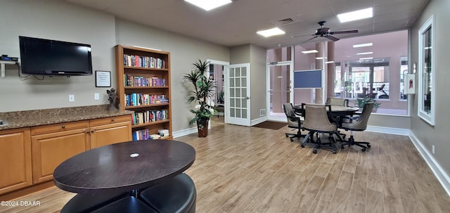 home office with french doors, light hardwood / wood-style floors, and ceiling fan