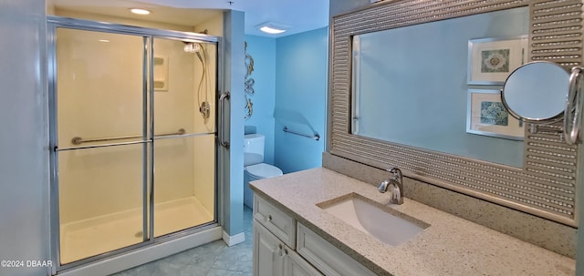 bathroom with tile patterned floors, vanity, and a shower with door