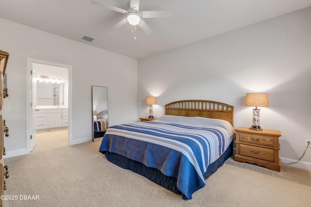 bedroom featuring ensuite bath, light carpet, and ceiling fan