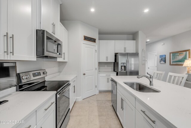 kitchen featuring sink, white cabinets, light stone countertops, and appliances with stainless steel finishes