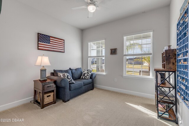 living area with ceiling fan and light colored carpet