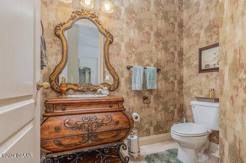 bathroom featuring toilet, vanity, and baseboards