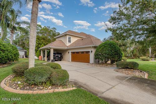 mediterranean / spanish-style house featuring a garage, driveway, stucco siding, and a front lawn