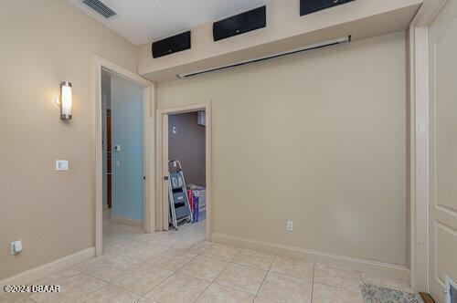 unfurnished room featuring light tile patterned floors, visible vents, and baseboards