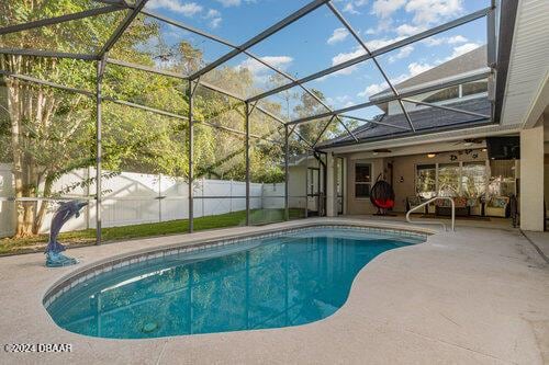 view of pool with a lanai, a patio area, a fenced in pool, and fence