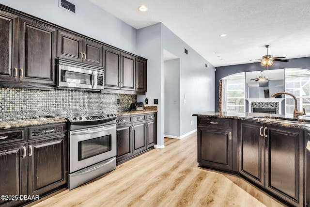 1001 Grassy Rdg, Port Orange, FL 32127 - kitchen with stainless steel appliances, a sink, a ceiling fan, decorative backsplash, and baseboards