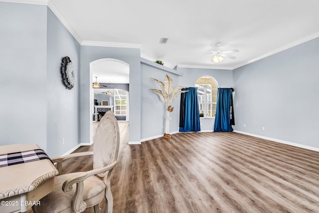 1001 Grassy Rdg, Port Orange, FL 32127 - unfurnished living room with ceiling fan, baseboards, crown molding, wood finished floors, and arched walkways