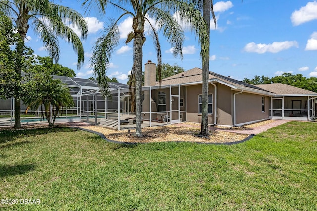 1001 Grassy Rdg, Port Orange, FL 32127 - back of house with a chimney, stucco siding, a yard, and a sunroom