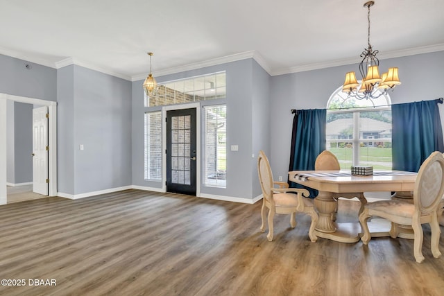 1001 Grassy Rdg, Port Orange, FL 32127 - dining room featuring a chandelier, healthy amount of natural light, wood finished floors, baseboards, and crown molding