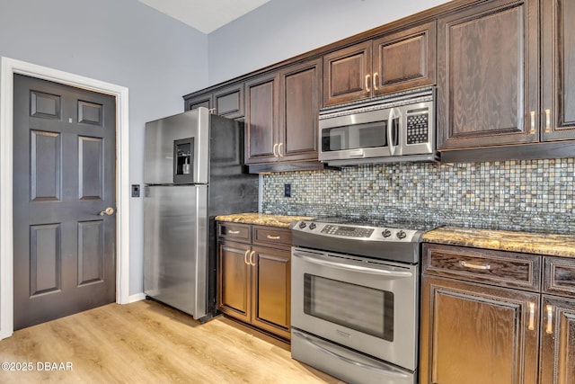 1001 Grassy Rdg, Port Orange, FL 32127 - kitchen featuring appliances with stainless steel finishes, light wood-style flooring, backsplash, and light stone countertops