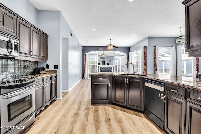 1001 Grassy Rdg, Port Orange, FL 32127 - kitchen featuring stainless steel appliances, a sink, decorative backsplash, light wood-type flooring, and a ceiling fan