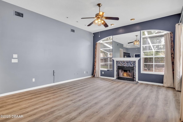 1001 Grassy Rdg, Port Orange, FL 32127 - unfurnished living room with a ceiling fan, wood finished floors, baseboards, and a tiled fireplace