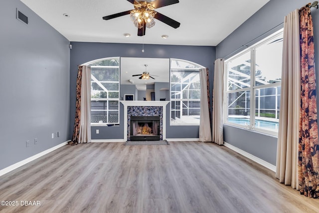 1001 Grassy Rdg, Port Orange, FL 32127 - unfurnished living room featuring a ceiling fan, wood finished floors, healthy amount of natural light, and a tile fireplace
