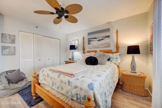 bedroom with light wood-type flooring, ceiling fan, and a closet