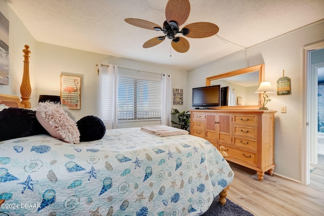 bedroom with light hardwood / wood-style floors, ceiling fan, and a textured ceiling