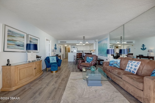 living room with a textured ceiling and light hardwood / wood-style floors