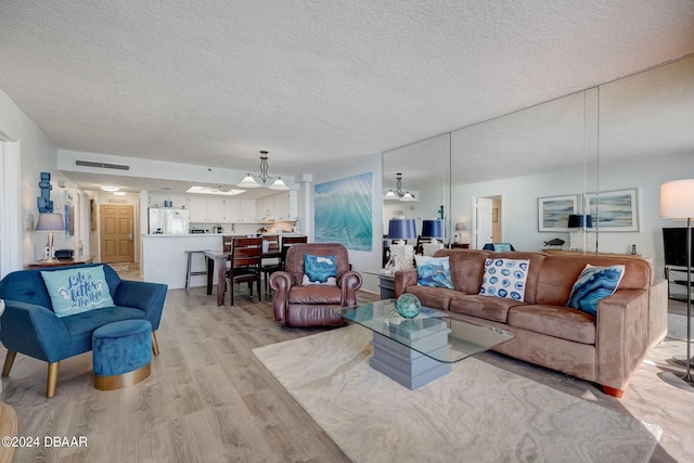 living room featuring a textured ceiling and light hardwood / wood-style floors