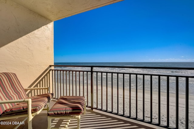 balcony featuring a water view and a view of the beach