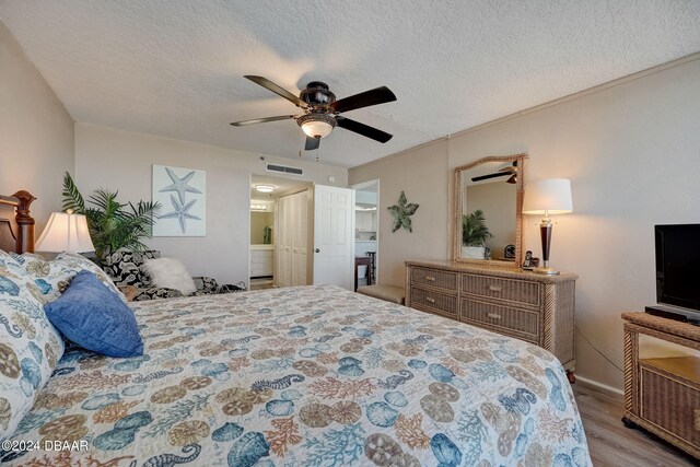 bedroom with a textured ceiling, light hardwood / wood-style flooring, and ceiling fan