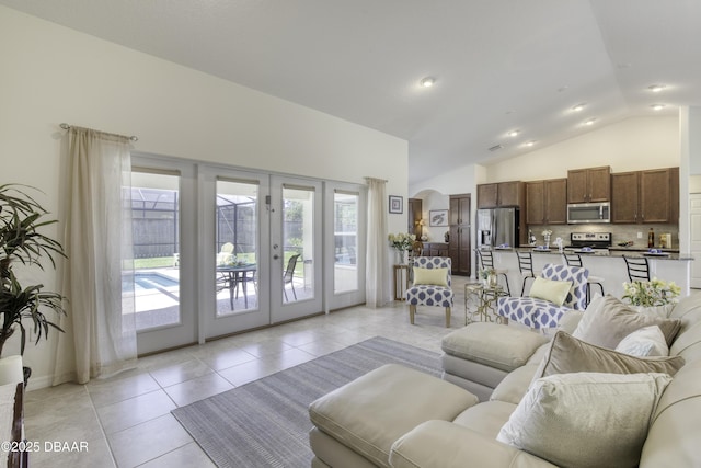 living area featuring light tile patterned flooring, french doors, and high vaulted ceiling