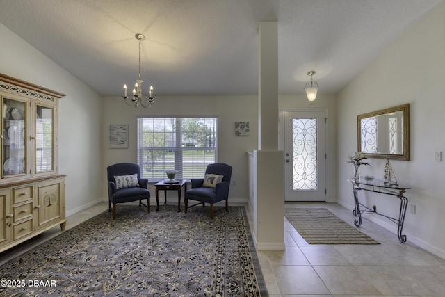 foyer entrance with an inviting chandelier, vaulted ceiling, light tile patterned flooring, and baseboards