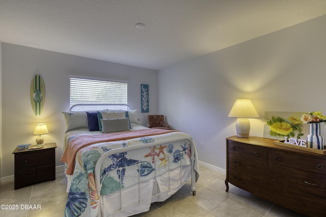 bedroom with light tile patterned floors and baseboards