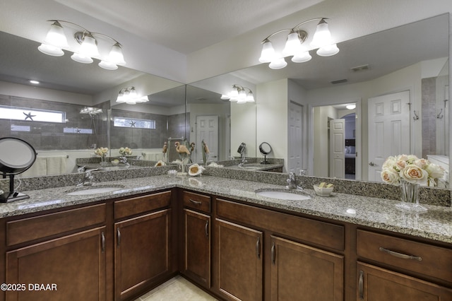 bathroom featuring a sink, visible vents, walk in shower, and double vanity