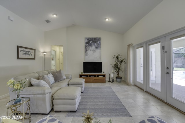 living area featuring light tile patterned floors, visible vents, lofted ceiling, and french doors