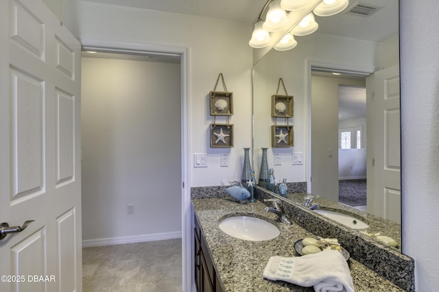 bathroom with a chandelier, visible vents, vanity, and baseboards