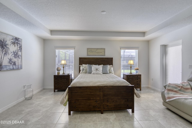 bedroom featuring light tile patterned floors, baseboards, and a textured ceiling