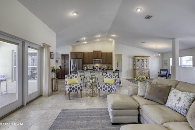 living area with visible vents, a notable chandelier, light tile patterned floors, baseboards, and vaulted ceiling