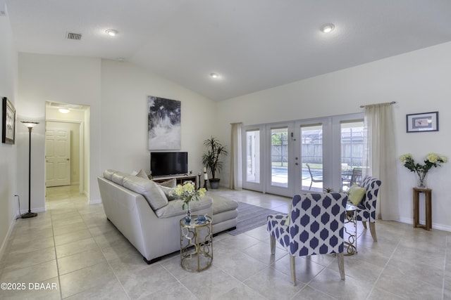 living area featuring light tile patterned floors, visible vents, french doors, and vaulted ceiling