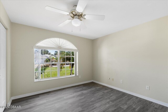 empty room with dark hardwood / wood-style flooring and ceiling fan