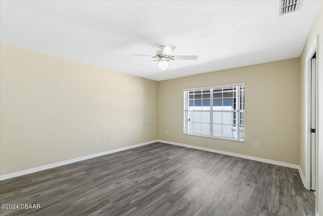 spare room featuring dark wood-type flooring and ceiling fan