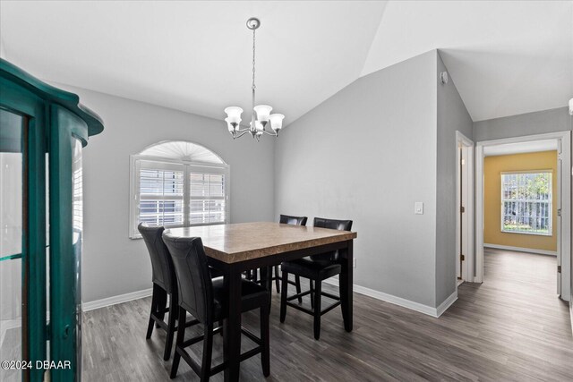 dining room with lofted ceiling, dark wood-type flooring, and a chandelier