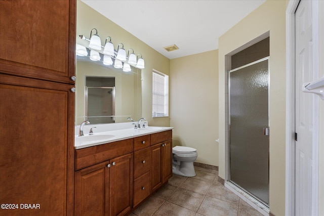 bathroom featuring walk in shower, vanity, toilet, and tile patterned floors