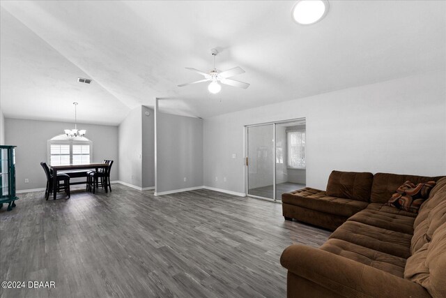 living room featuring dark hardwood / wood-style flooring, ceiling fan with notable chandelier, and lofted ceiling